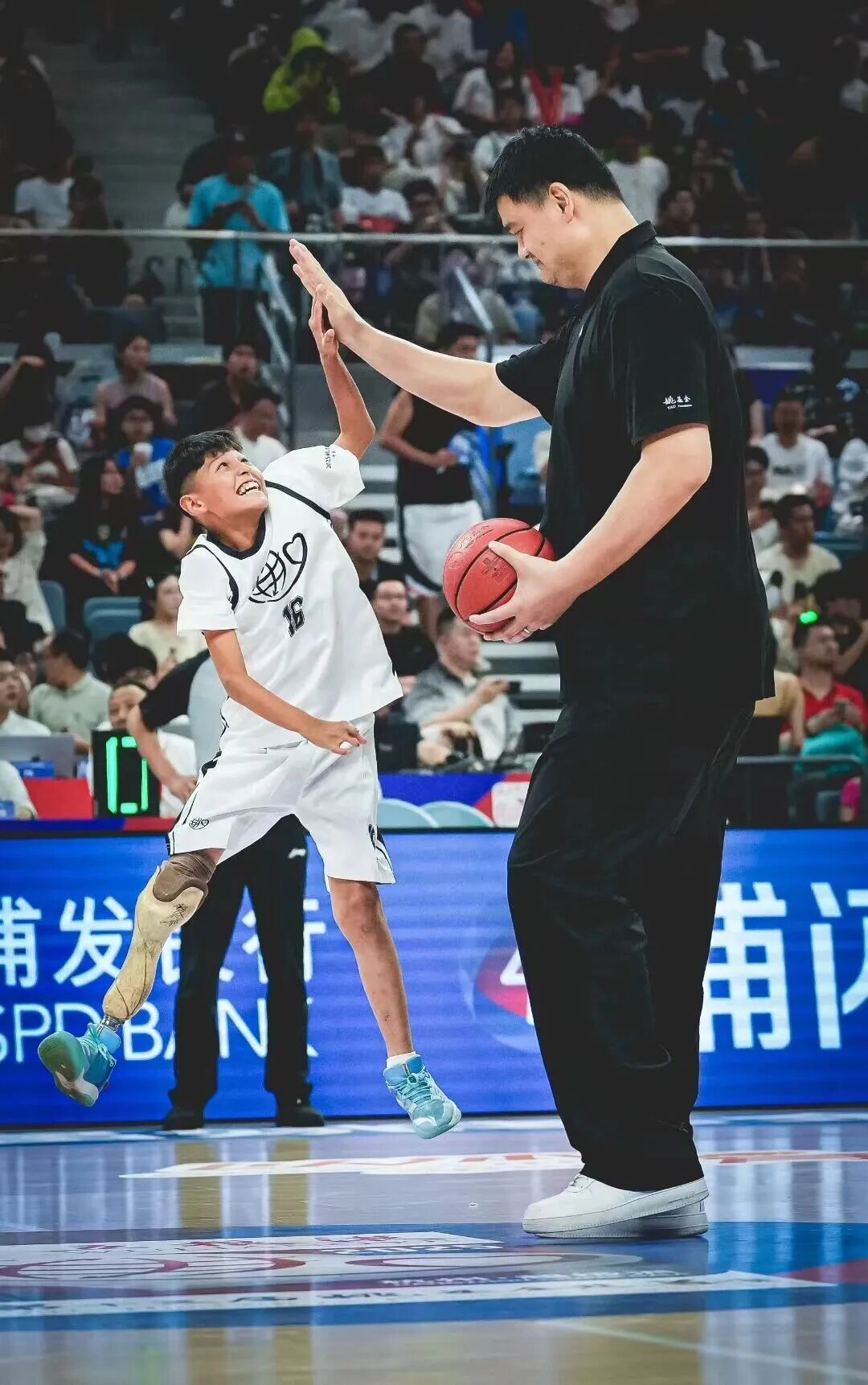 麥麥提吐爾遜江·艾爾肯與姚明擊掌